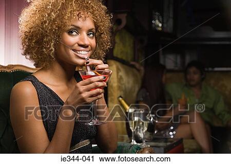 Portrait of a woman drinking a cocktail View Large Photo Image Stock Image - Portrait of a woman drinking a cocktail. Fotosearch
