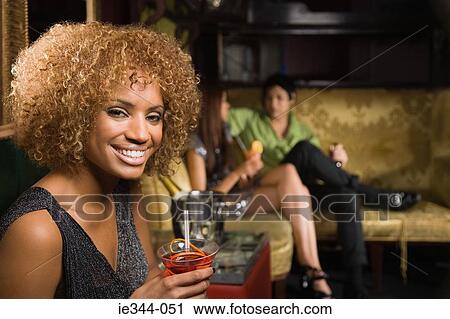 Portrait of a woman holding a cocktail View Large Photo Image Stock Image - Portrait of a woman holding a cocktail. Fotosearch