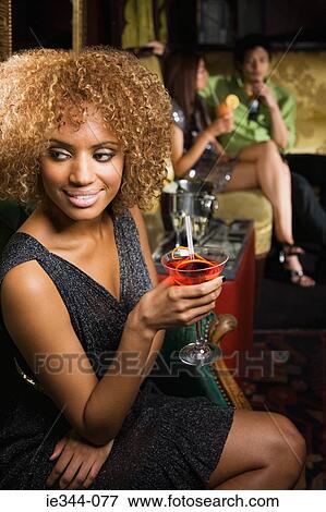 Stock Photo - Portrait of a woman holding a cocktail. Fotosearch
