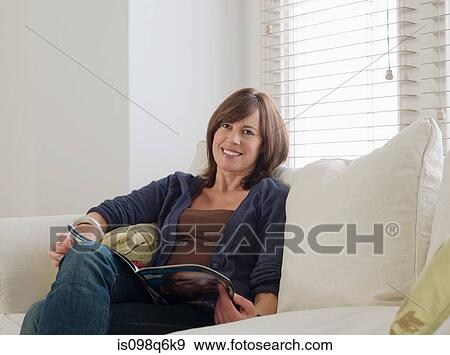 Portrait of a woman holding a magazine View Large Photo Image Stock Photo - Portrait of a woman holding a magazine. Fotosearch