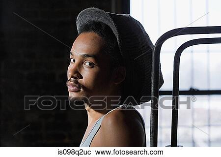Stock Image - Portrait of a young man wearing a hat. Fotosearch
