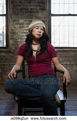 Portrait of a young woman sat on a chair View Large Photo Image Picture - Portrait of a young woman sat on a chair. Fotosearch