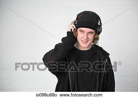 Picture - Portrait of teenage boy listening to music on headphones. Fotosearch