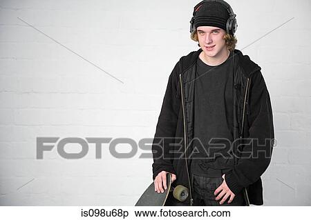Stock Photography - Portrait of teenage boy with skateboard. Fotosearch