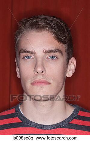 Stock Photography - Portrait of young man against red background. Fotosearch