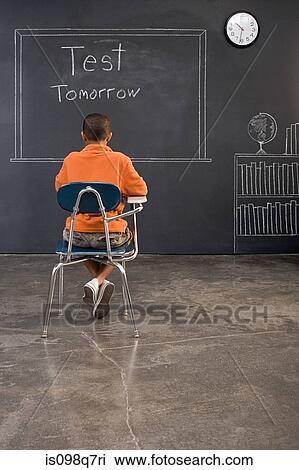 Rear view of a boy sat at a desk View Large Photo Image Stock Image - Rear view of a boy sat at a desk. Fotosearch