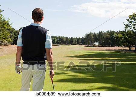 Stock Photo - Rear view of a male golfer on the fairway. Fotosearch