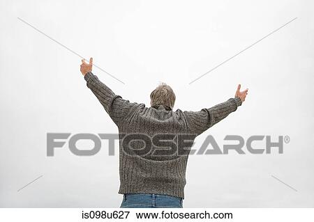 Stock Photo - Rear view of man with arms raised. Fotosearch
