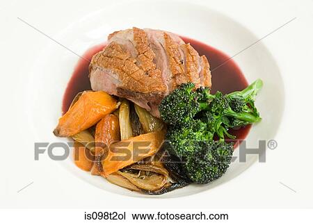 Stock Image - Roast duck with vegetables and jus. Fotosearch