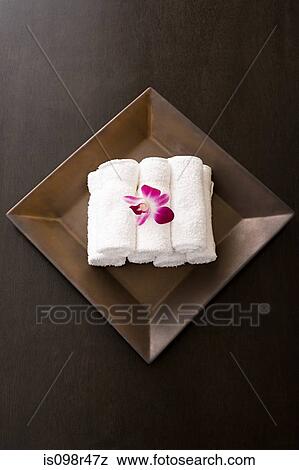 Stock Photo - Rolled up towels and orchids. Fotosearch