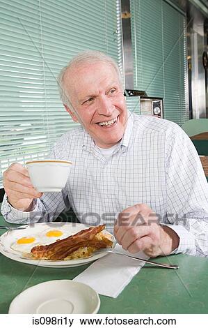 Senior man eating a fried breakfast View Large Photo Image Stock Photo - Senior man eating a fried breakfast. Fotosearch