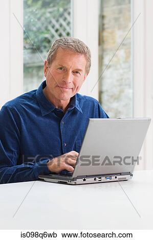 Senior man using a laptop View Large Photo Image Stock Image - Senior man using a laptop. Fotosearch