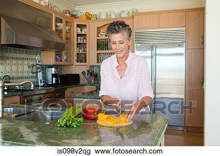 Senior woman chopping peppers in kitchen View Large Photo Image Stock Image - Senior woman chopping peppers in kitchen. Fotosearch