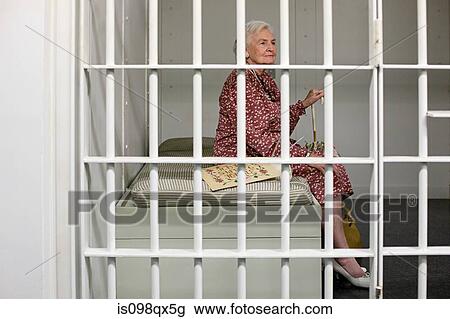 Stock Image - Senior woman in prison cell. Fotosearch