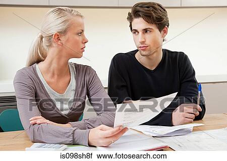 Stock Image - Serious young couple doing home finances. Fotosearch