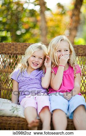 Sisters sitting on seat in garden View Large Photo Image Stock Photo - Sisters sitting on seat in garden. Fotosearch