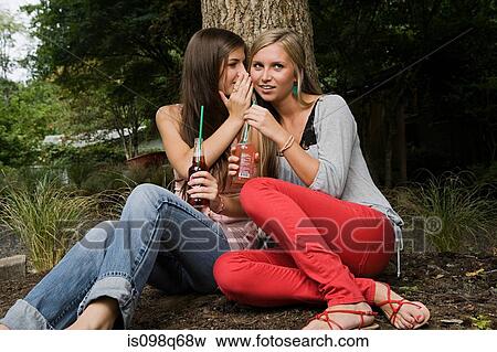 Stock Photo - Sisters whispering. Fotosearch