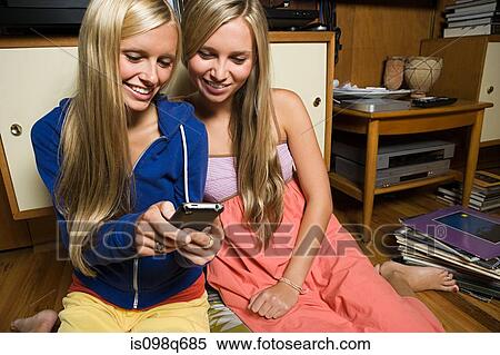 Sisters with cellphone View Large Photo Image Stock Photography - Sisters with cellphone. Fotosearch