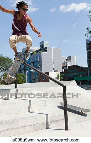 Picture - Skateboarder jumping over a rail. Fotosearch