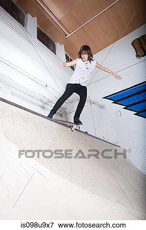 Stock Photo - Skateboarder on ramp at skate park. Fotosearch