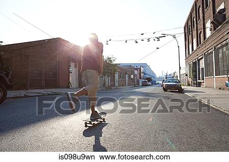 Skateboarder on urban street in sunlight View Large Photo Image Picture - Skateboarder on urban street in sunlight. Fotosearch