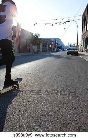 Stock Photo - Skateboarder on urban street in sunlight. Fotosearch