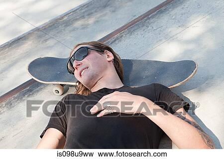 Skater lying on his board View Large Photo Image Stock Photo - Skater lying on his board. Fotosearch
