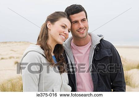 Smiling couple on a beach View Large Photo Image Stock Photograph - Smiling couple on a beach. Fotosearch