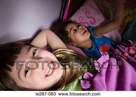 Smiling girls in bed View Large Photo Image Stock Image - Smiling girls in bed. Fotosearch