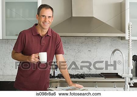 Smiling mature man in kitchen View Large Photo Image Stock Photograph - Smiling mature man in kitchen. Fotosearch