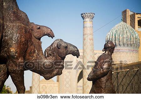 Picture - Statue of man leading camels outside mosque. Fotosearch