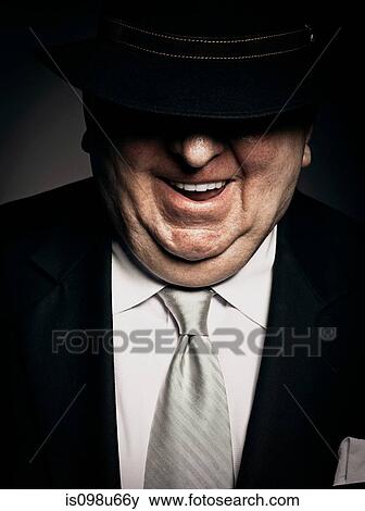 Studio portrait of gangster with hat covering face View Large Photo Image Stock Photo - Studio portrait of gangster with hat covering face. Fotosearch