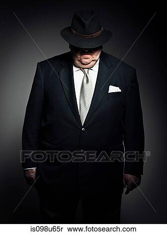 Studio portrait of gangster with hat covering face View Large Photo Image Stock Photography - Studio portrait of gangster with hat covering face. Fotosearch
