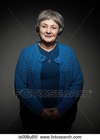Stock Image - Stuido portrait of cheerful senior woman. Fotosearch