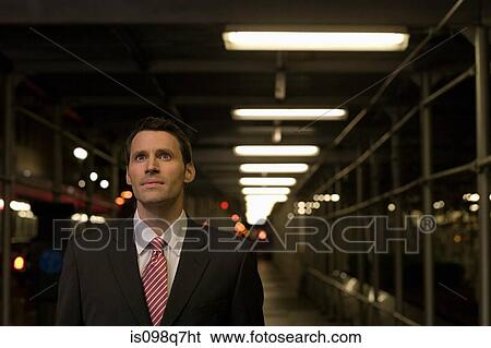 Stock Photograph - Stunned looking businessman in a walkway. Fotosearch
