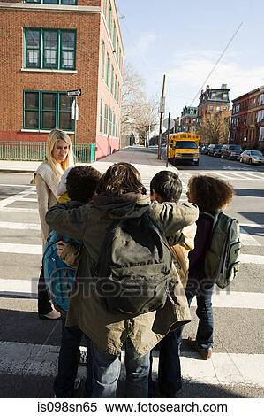 Teacher and children by pedestrian crossing View Large Photo Image Stock Photography - Teacher and children by pedestrian crossing. Fotosearch
