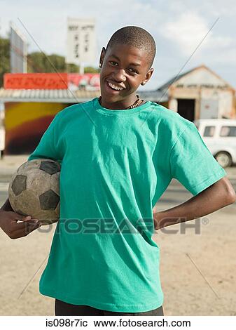 Stock Image - Teenage african boy with football. Fotosearch
