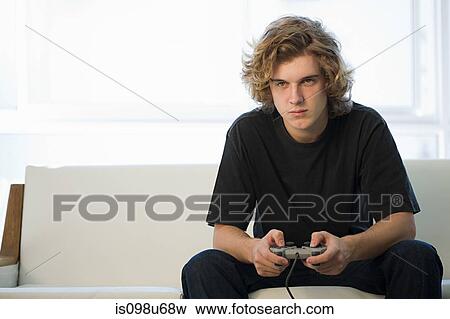 Teenage boy playing on games console View Large Photo Image Stock Photo - Teenage boy playing on games console. Fotosearch