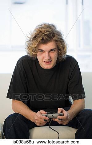 Teenage boy playing on games console View Large Photo Image Stock Photograph - Teenage boy playing on games console. Fotosearch