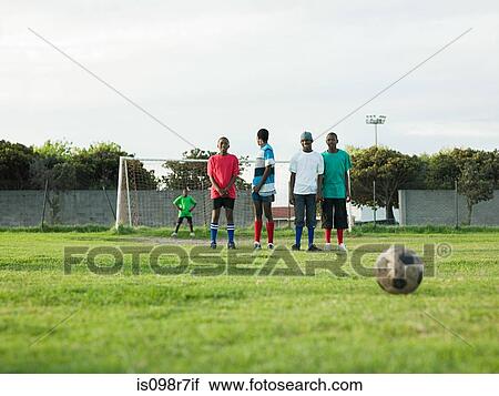 Stock Image - Teenage boys playing football. Fotosearch