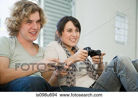 Teenage couple playing with games consoles View Large Photo Image Picture - Teenage couple playing with games consoles. Fotosearch