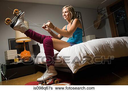Stock Photograph - Teenage girl putting on roller skates. Fotosearch