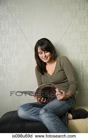 Stock Image - Teenage girl reading magazine. Fotosearch