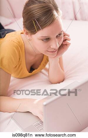 Teenage girl using a laptop View Large Photo Image Picture - Teenage girl using a laptop. Fotosearch
