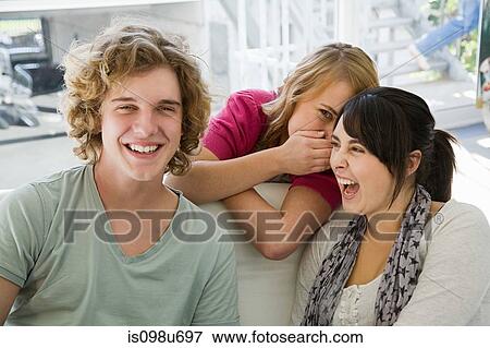 Teenage girl whispering to one of her friends View Large Photo Image Stock Photo - Teenage girl whispering to one of her friends. Fotosearch