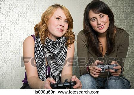 Teenage girls playing on games console View Large Photo Image Picture - Teenage girls playing on games console. Fotosearch