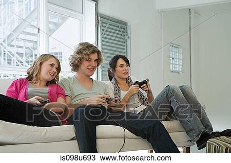 Teenagers playing on games console View Large Photo Image Stock Image - Teenagers playing on games console. Fotosearch