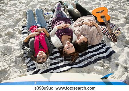 Three girls lying on beach with guitar View Large Photo Image Stock Image - Three girls lying on beach with guitar. Fotosearch