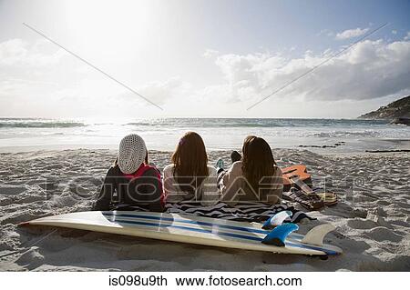 Three girls lying on beach with surfboard View Large Photo Image Stock Image - Three girls lying on beach with surfboard. Fotosearch