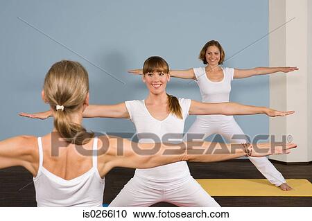 Stock Image - Three women practising yoga. Fotosearch
